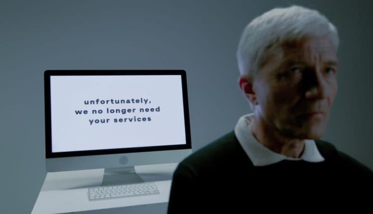 Elderly man and screen with information that his services are no longer needed