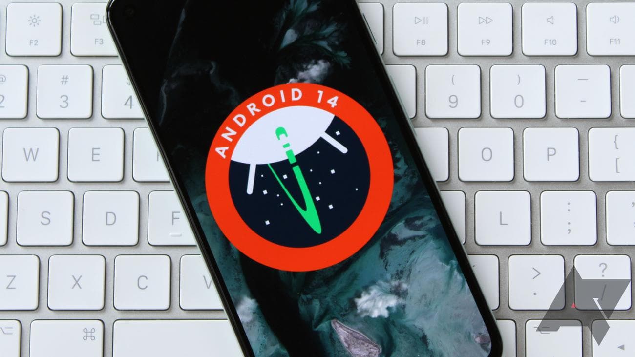 Το λογότυπο Android 14 που εμφανίζεται σε ένα smartphone που στηρίζεται σε ένα πληκτρολόγιο της Apple.