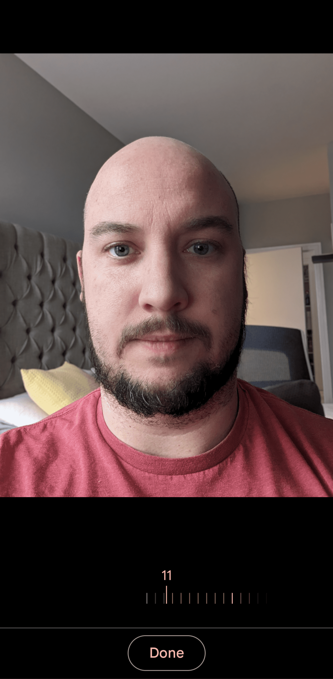 Μια εικόνα ενός ατόμου με κόκκινο πουκάμισο στην εφαρμογή κάμερας Pixel με το ρυθμιστικό θαμπώματος εστιασμένο. 