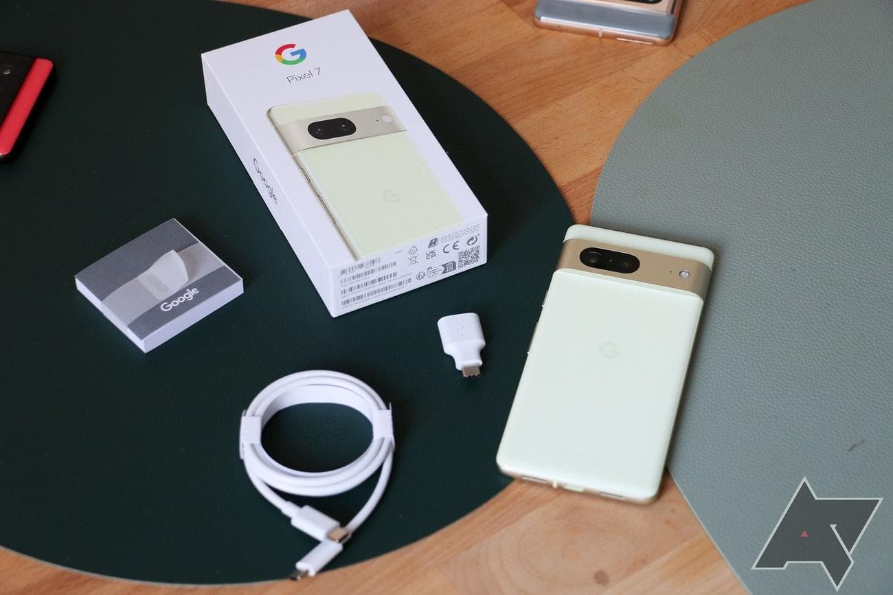 Το Google Pixel 7 και τα περιεχόμενα του κουτιού του απλώνονται σε μια επιφάνεια.