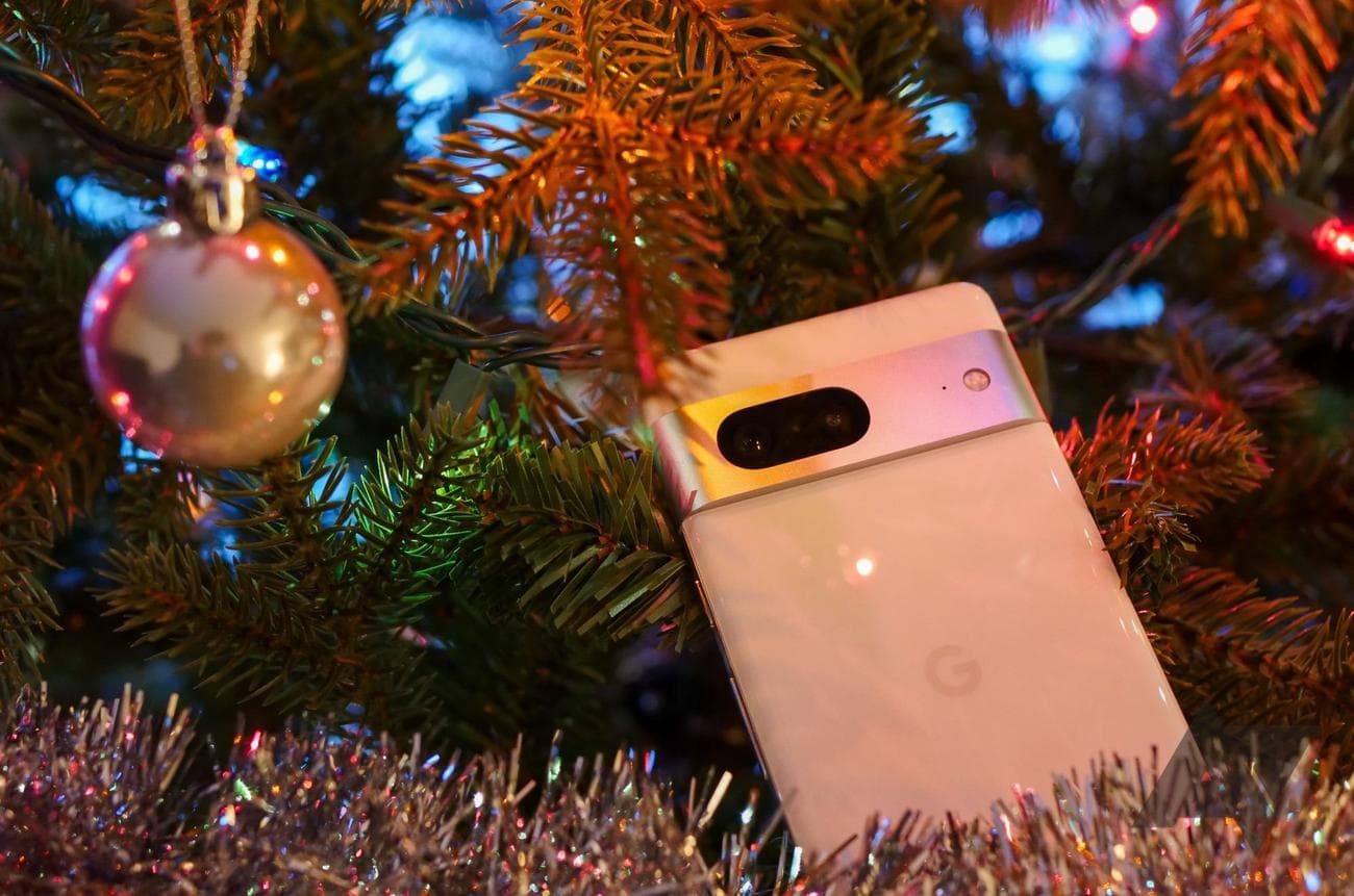 A white Google Pixel 7 draped on a Christmas tree full of ornaments