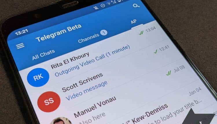 Close up of a phone with Telegram opened in the group tab. 