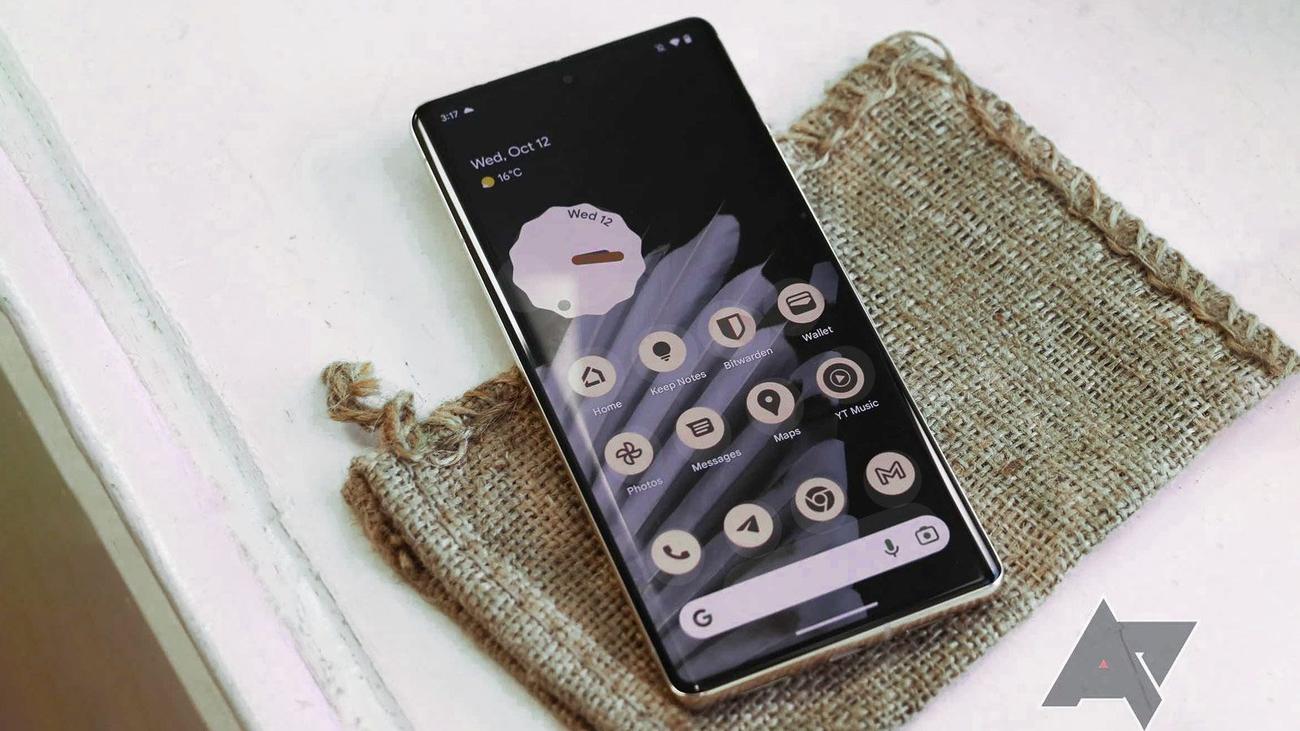 Ένα Pixel 7 Pro κάθεται πάνω από μια λινάτσα και μια ταλαιπωρημένη λευκή επιφάνεια. 