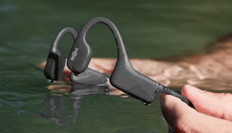 Holding Shokz Bone Conduction Headphones in water