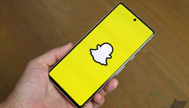 Hand holding a smartphone with Snapchat app