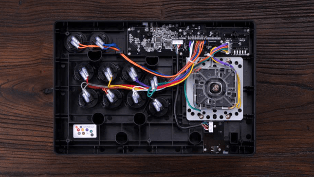 Η μαύρη έκδοση του 8BitDo Wireless Arcade Stick για Xbox αναποδογυρίστηκε και το πίσω πλαίσιο αφαιρέθηκε αποκαλύπτοντας τα εξαρτήματα που μπορούν να αλλάξουν μέσα.