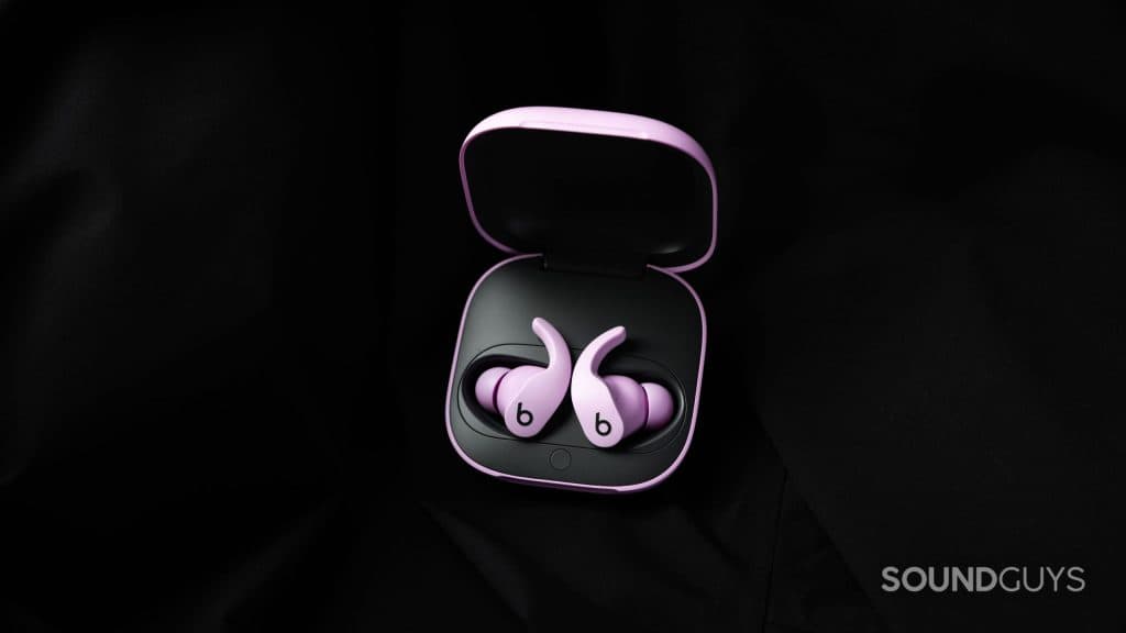 Τα ακουστικά Beats Fit Pro στη θήκη τους σε μαύρο φόντο.