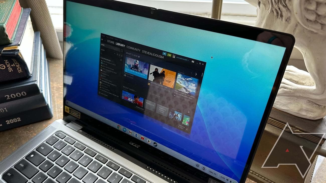 Ένα Acer Chromebook Spin 514 με το Steam ανοιχτό σε ένα γραφείο με βιβλία και ένα άγαλμα στο φόντο