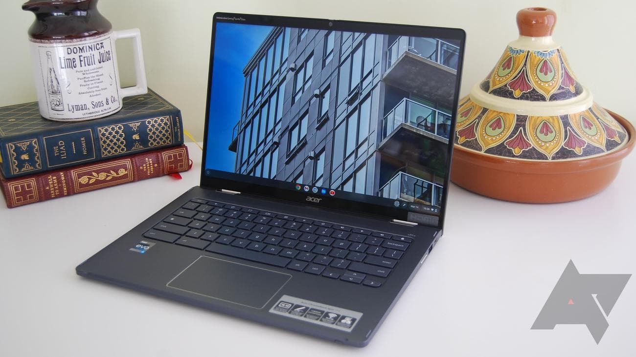 The Acer Chromebook Spin 714 on a white table with some books and a pot behind it