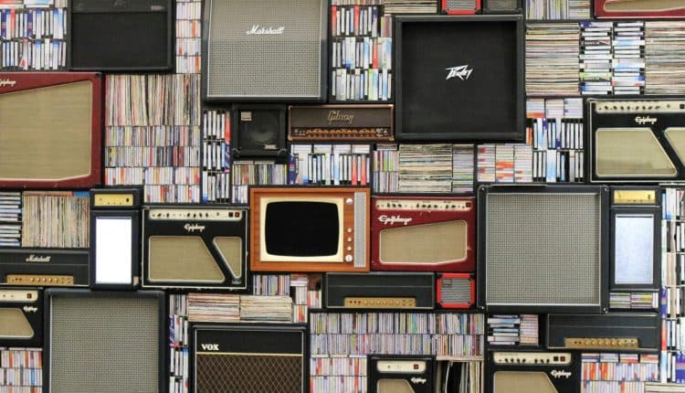 televisions and speakers against a wall of books