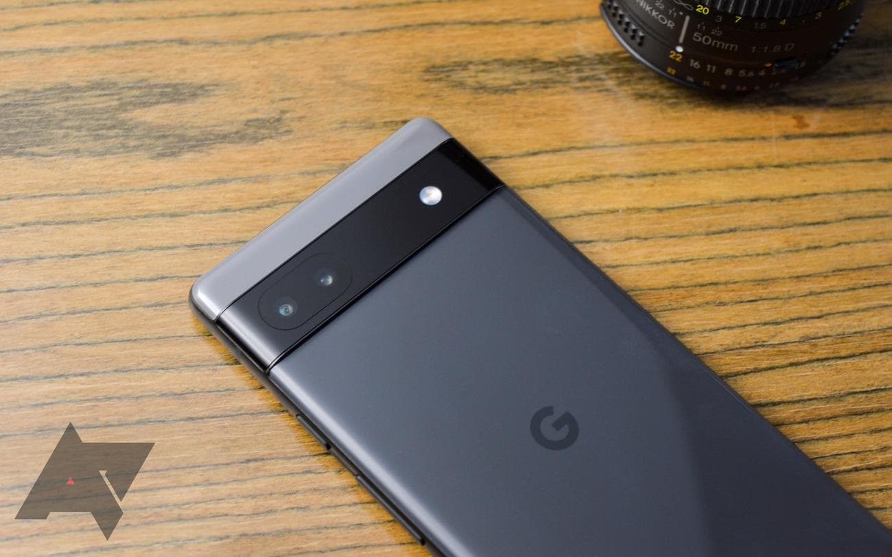 A gray phone with the Google logo with camera bar in focus on a woodgrain table