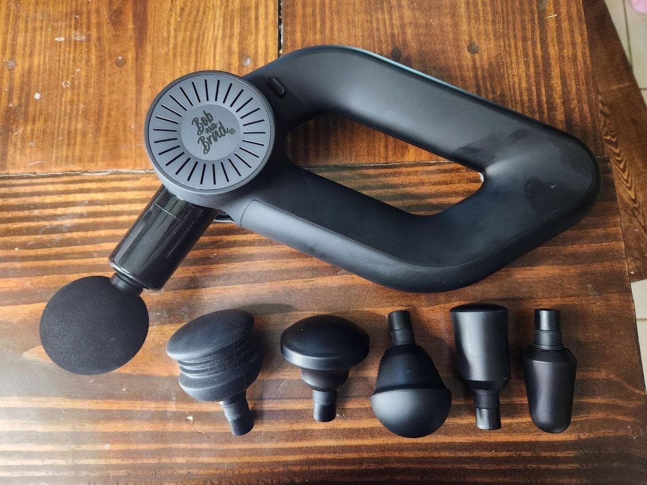 πιστόλι μασάζ τοποθετημένο σε tablet με έξι εναλλάξιμα εξαρτήματα