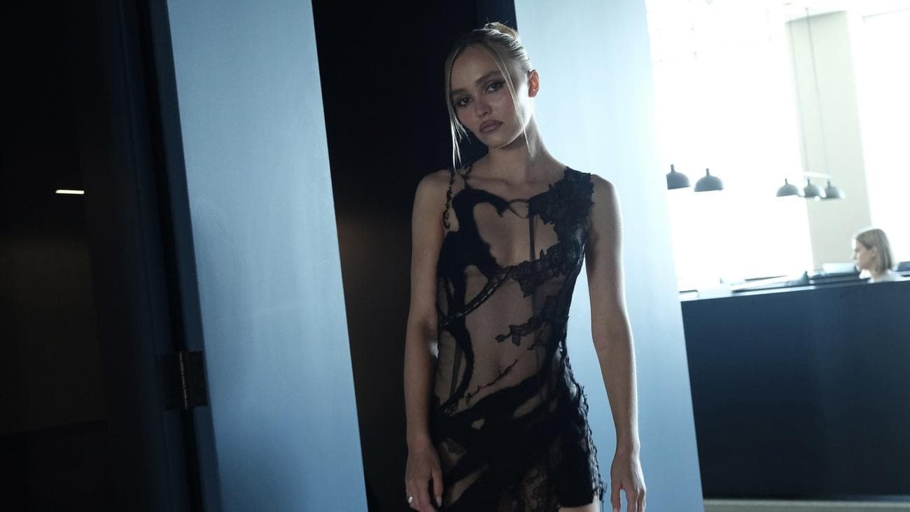 Μια γυναίκα με ένα καθαρό μαύρο φόρεμα μπαίνει σε ένα γραφείο.