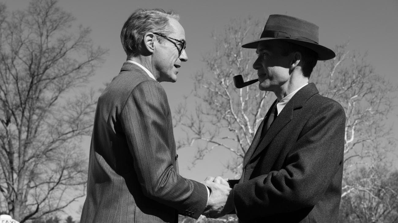 Μια ασπρόμαυρη φωτογραφία δύο ανδρών που κάνουν χειραψία. 