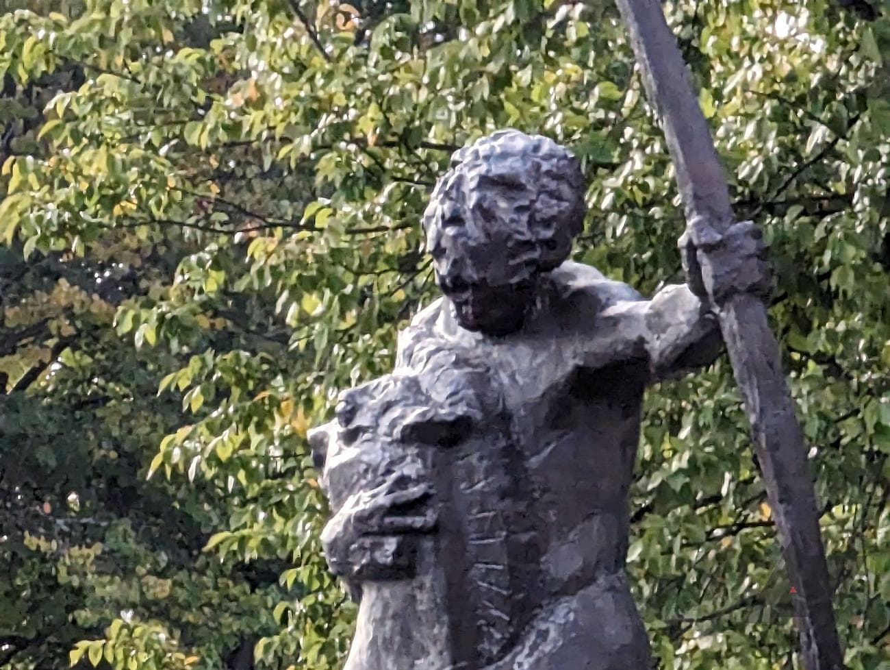 photo of grey statue in front of tree