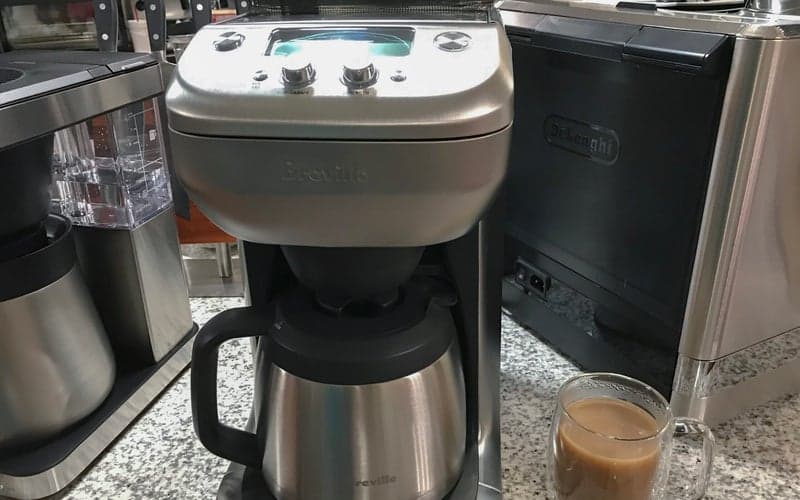 Breville Grind Control best with grinder chrome drip coffee maker on a crowded kitchen counter
