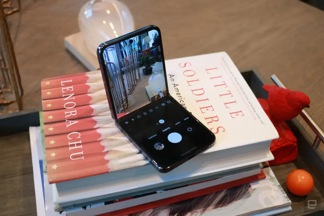 The Samsung Galaxy Z Flip 5 folded at a 90-degree angle and sitting on a stack of books with the camera app showing.