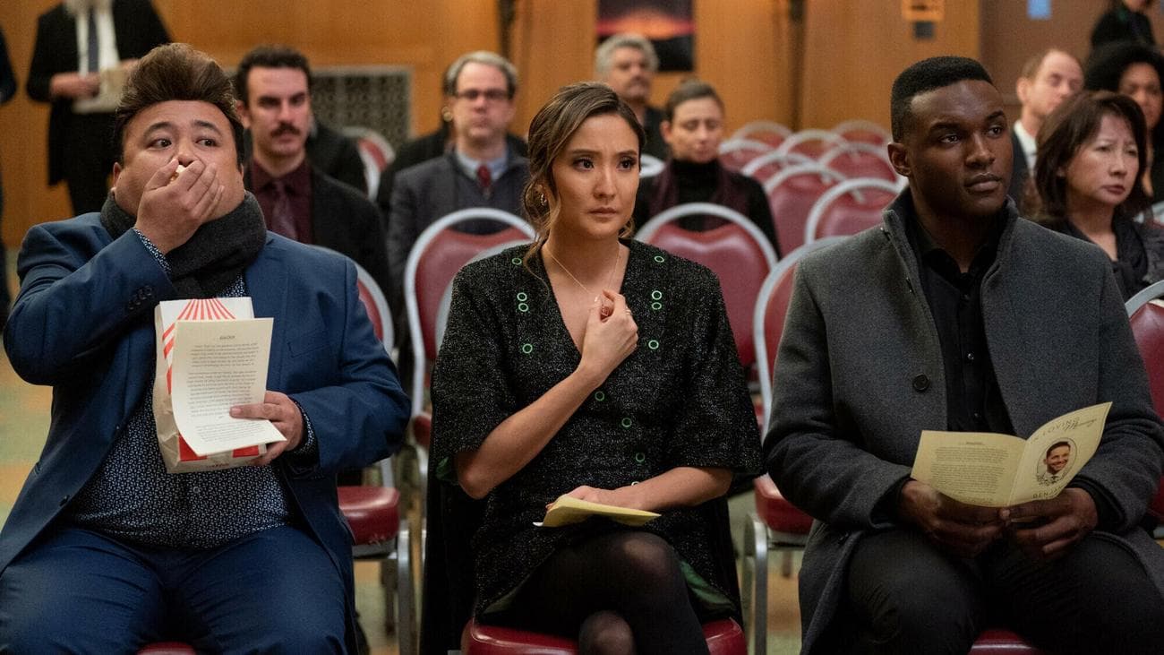 Two men and women sit in a funeral service. 