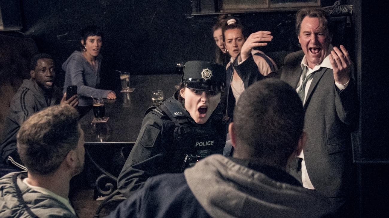 A police officer screams at a man surrounded by a crowd in the show "Blue Lights."