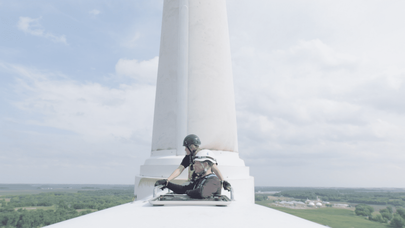 A still from "Paris to Pittsburgh" showing two people at the top of a wind turbine