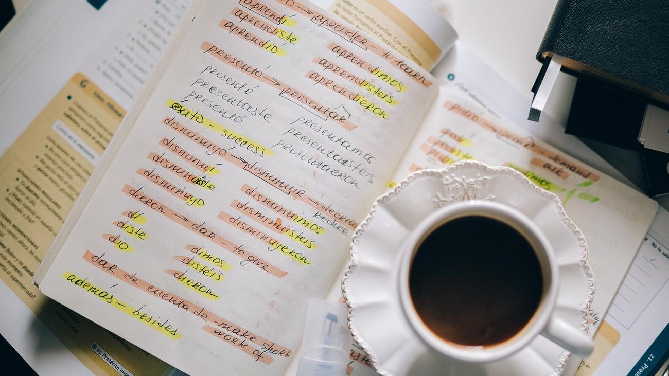 A notebook with Spanish verb conjugations, written probably in the process of learning two languages simultaneously