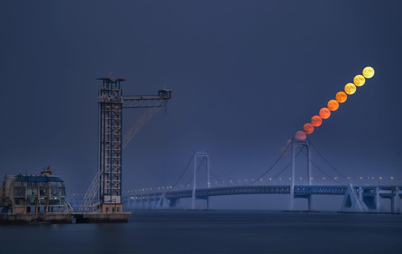 Timelapse of the moon rising over a bridge