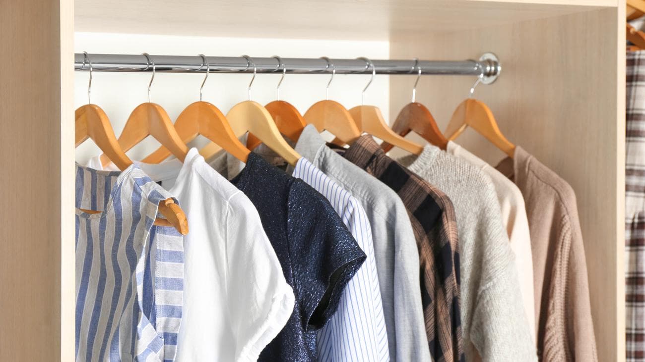 Ξύλινες κρεμάστρες που κρατούν τα ρούχα σε μια ντουλάπα