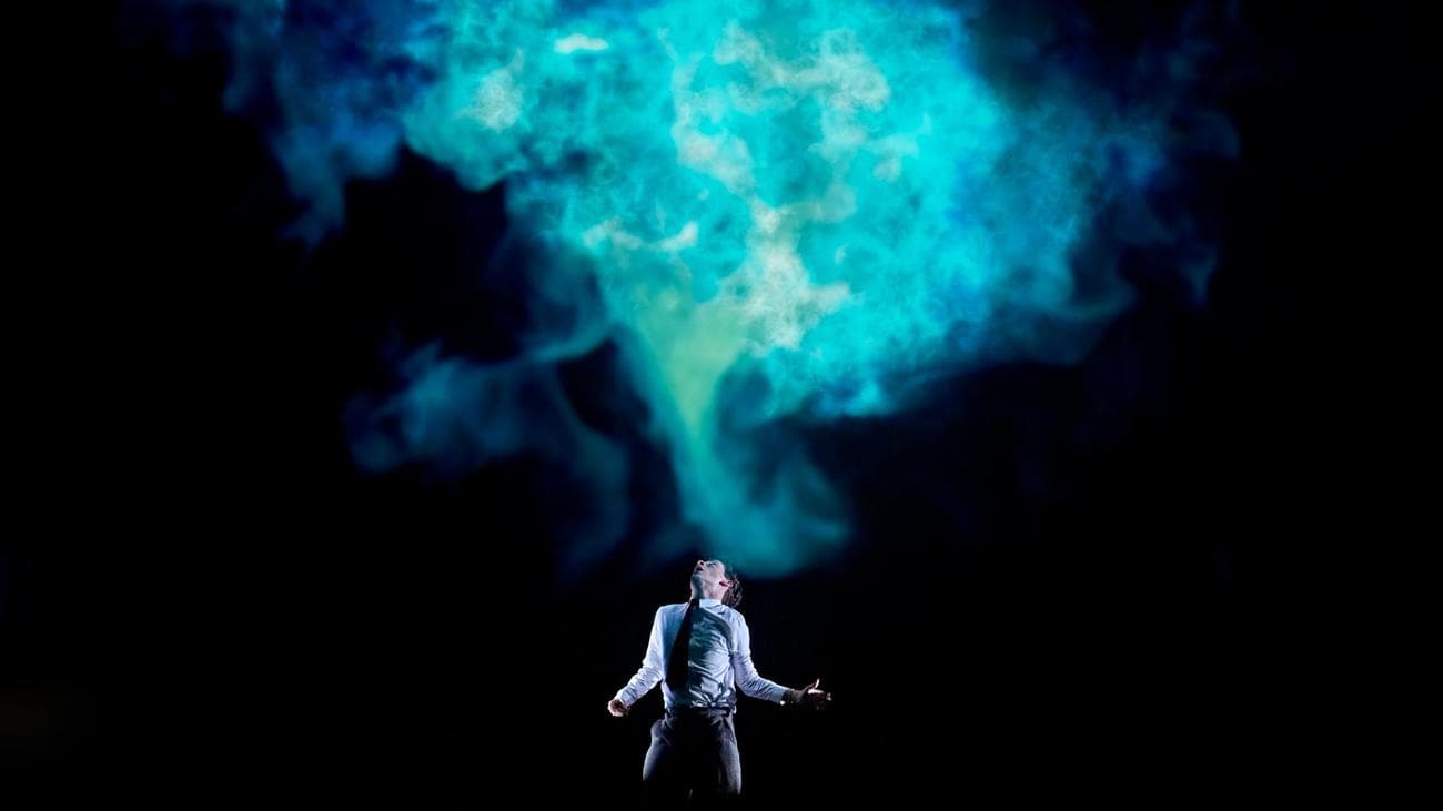 Σε "Stranger Things: The First Shadow" ένα αγόρι τυλίγεται από ένα πράσινο μπλε φως που φαίνεται να πηγάζει από αυτόν.