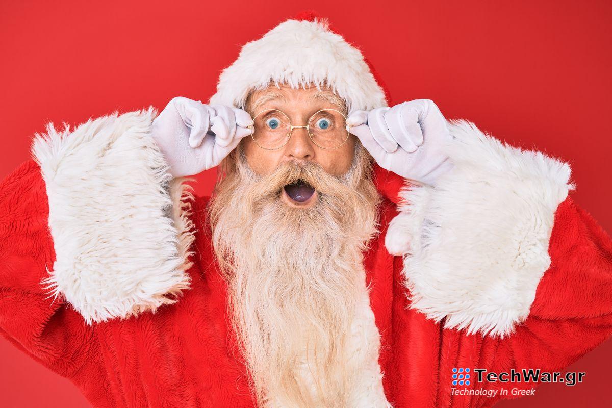 Father Christmas - an old man with white hair and a long white beard wearing a red fur-trimmed hat and coat and circular glasses - holds his glasses and opens his mouth in a shocked expression
