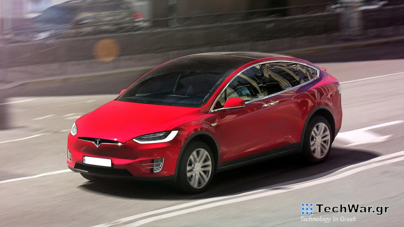 Red Tesla in motion down road