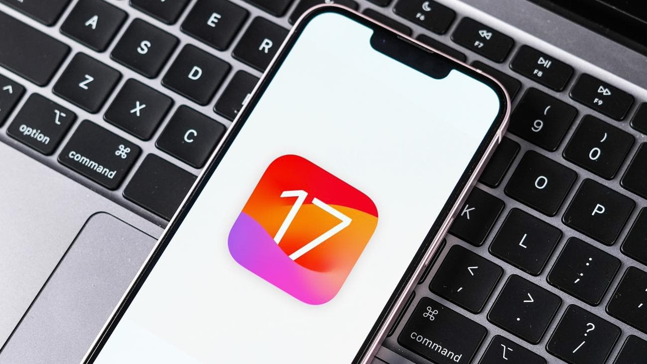 Λογότυπο iOS 17 στο iPhone που κάθεται στο πληκτρολόγιο MacBook