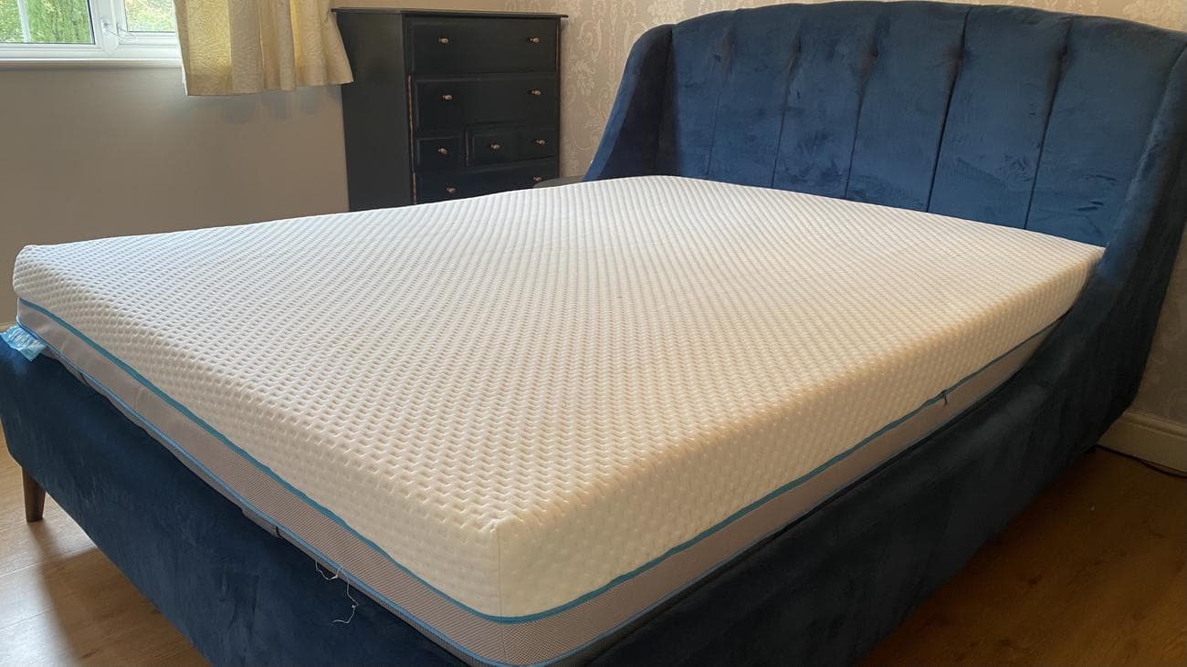 Simba Hybrid Ultra mattress shown on our reviewer's blue fabric bedframe