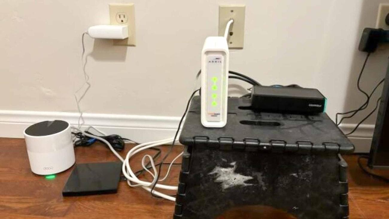 Ένα TP-Link Deco X55 δίπλα σε ένα καλωδιακό μόντεμ Arris SURFboard
