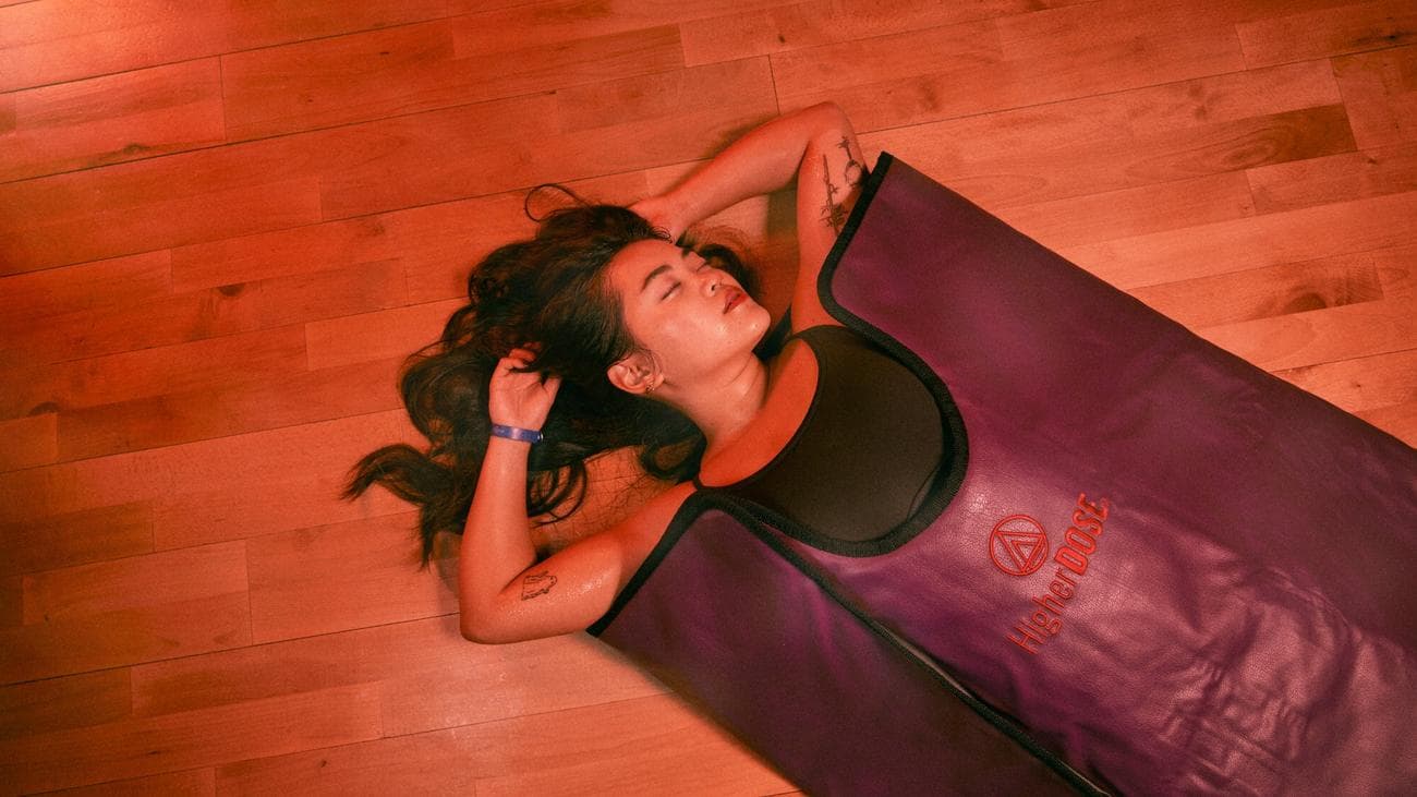 Γυναίκα ξαπλωμένη σε μια κουβέρτα σάουνας που φαίνεται χαλαρή