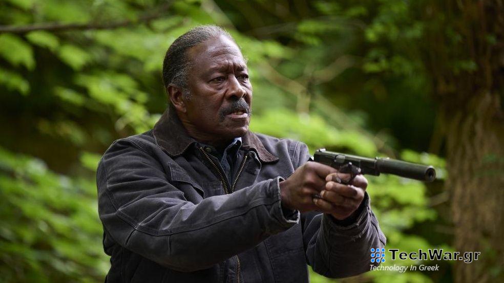Clarke Peters pointing a gun in a green forest in new thriller Truelove