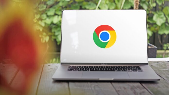 Το Google Chrome διαθέτει έναν μυστικό διακόπτη για να επιταχύνει A photo of the Google Chrome logo on a white background, displayed on the screen of a large MacBook Pro which is situated on a table with green foliage behind.
