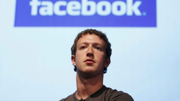 Mark Zuckerberg in front of an old Facebook logo