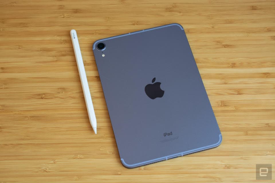 Φωτογραφία του iPad mini 6ης γενιάς που κάθεται σε ένα κομψό ξύλινο τραπέζι με την πλάτη του (με το λογότυπο της Apple) προς τα επάνω. Το Apple Pencil του βρίσκεται στα αριστερά του.