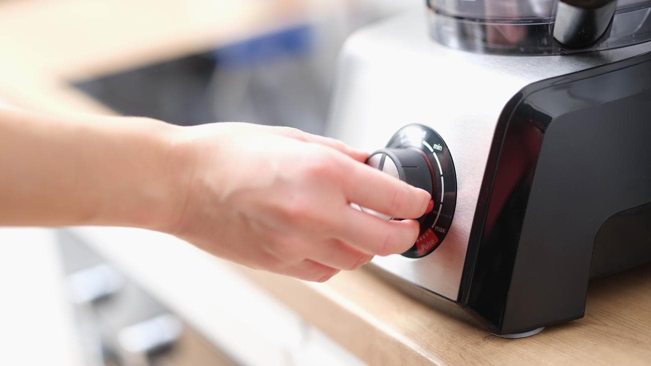 Κάποιος που προσαρμόζει τη ρύθμιση ισχύος σε ένα μπλέντερ