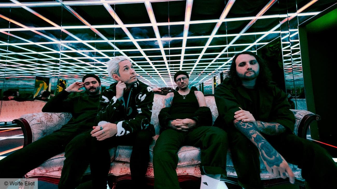 Μια ομάδα ανδρών που κάθονται σε έναν καναπέ πάνω σε μια ασπρόμαυρη οροφή