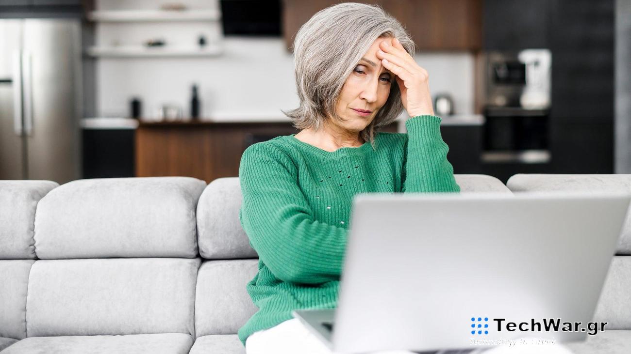 Upset senior woman looks at the laptop screen
