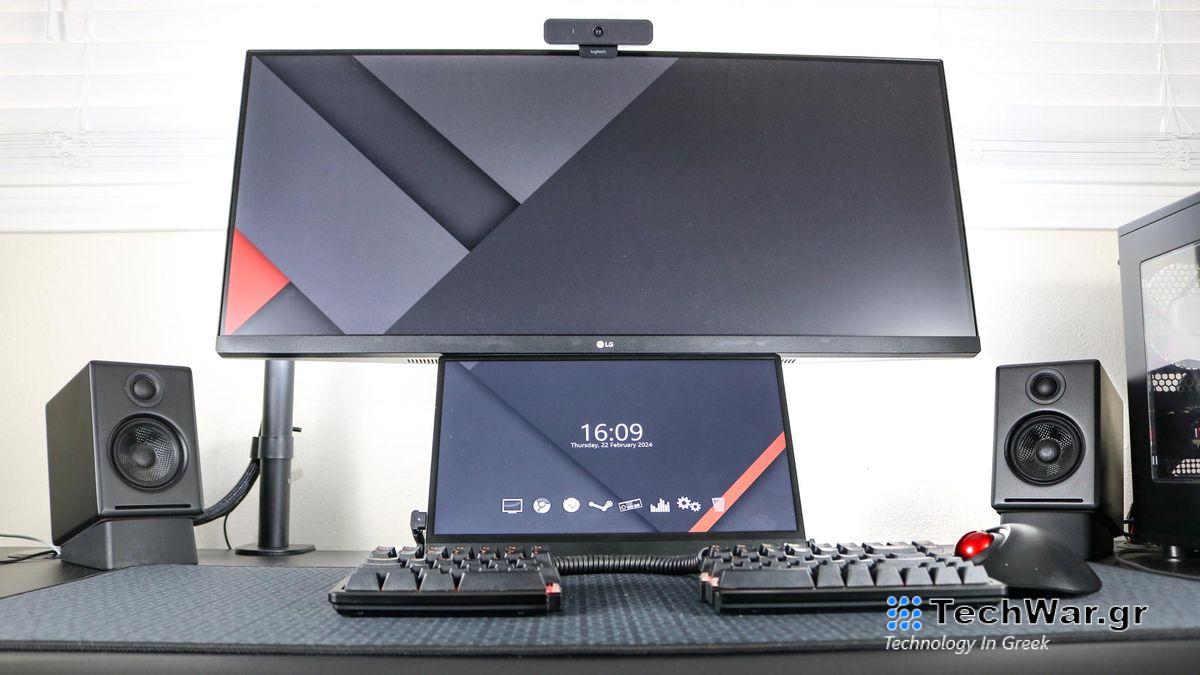 A portable monitor underneath an ultrawide monitor on a desk