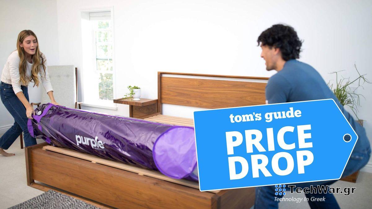 A young couple unrolling a Purple mattress on a wooden bedframe