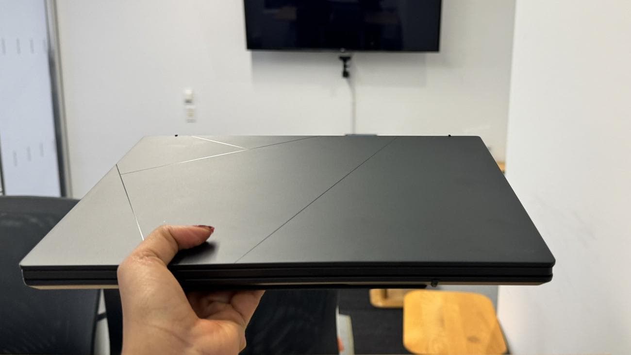 Γυναίκα που κρατά το Asus Zenbook Duo με το ένα χέρι