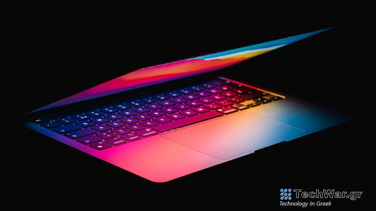 an almost-closed laptop with glowing rainbow light