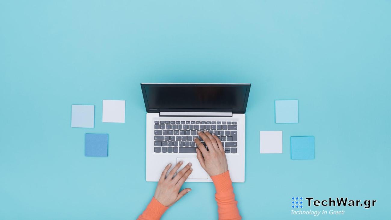 Woman working with a laptop and sticky notes