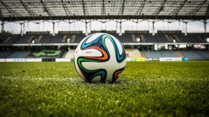 A football on grass in a stadium
