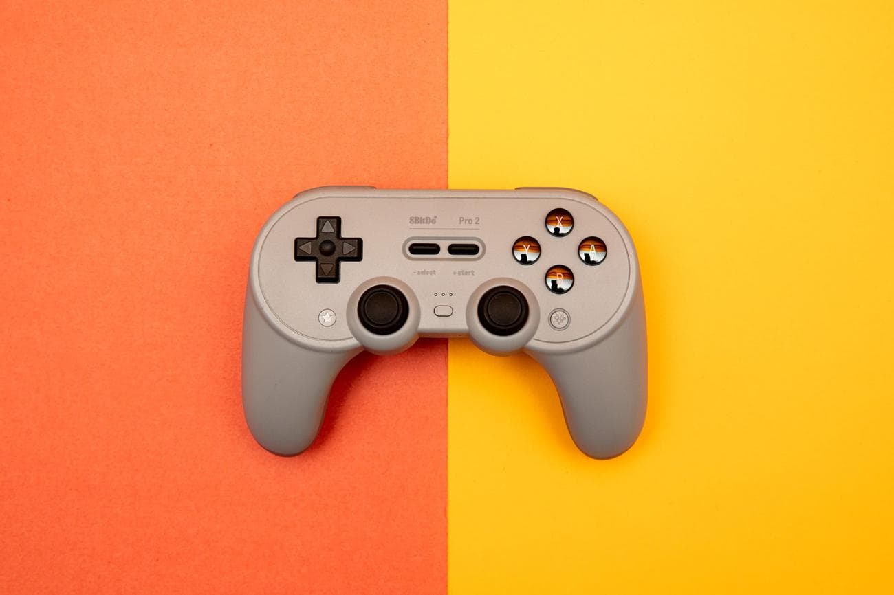 The 8BitDo Pro 2 wireless controller for the Nintendo Switch and other platforms sitting on a two-toned backdrop.