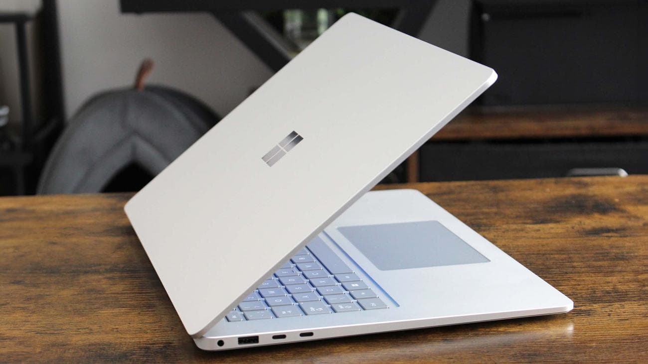 Surface Laptop 7 half closed showing Microsoft logo on the lid