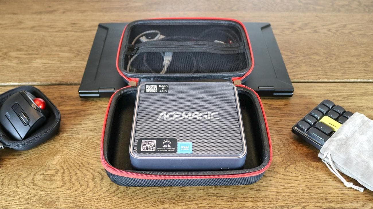 Ένα mini PC σε μια θήκη δίπλα σε ένα trackball ποντίκι και ένα μηχανικό πληκτρολόγιο σε ένα τραπέζι